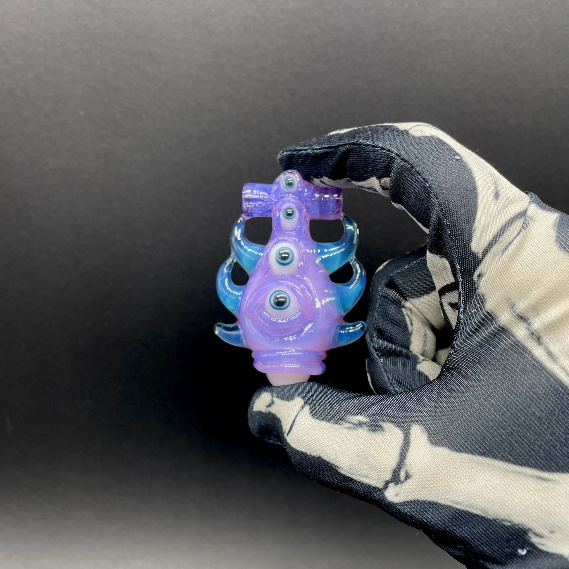 Close-up of Pink slime evil eye pendant - handcrafted glass
