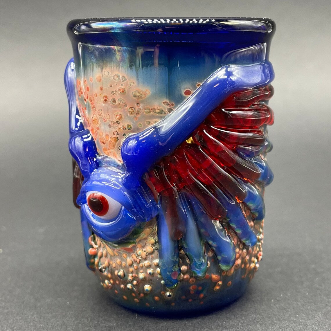 Close-up of Winged phoenix shot glass (blue) - handcrafted glass