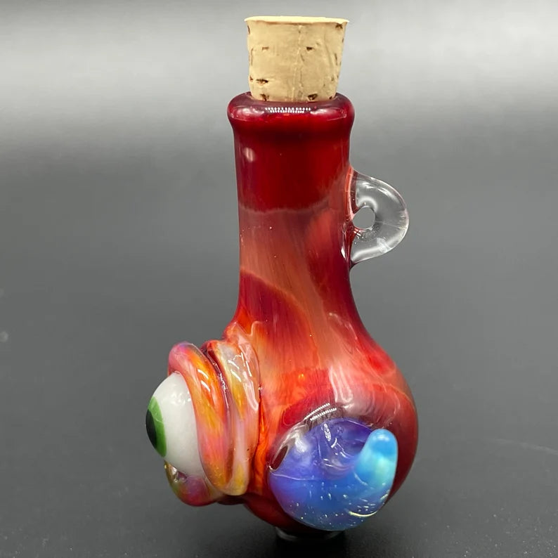 Close-up of Sunrise red cyclops potion bottle - handcrafted glass