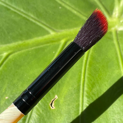 Close-up of Glass makeup brush with glow in the dark eye and carved ventral scales. - handcrafted glass