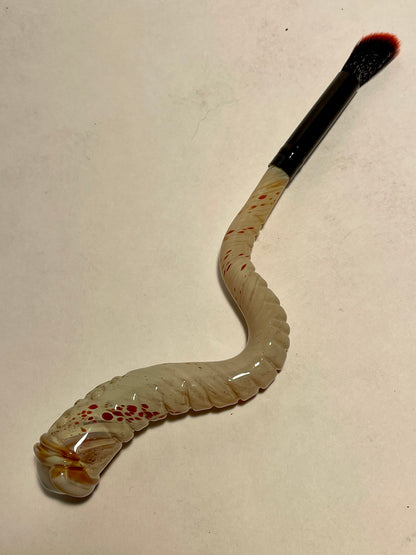 Glass makeup brush with glow in the dark eye and carved ventral scales. craftsmanship - artisan glass work